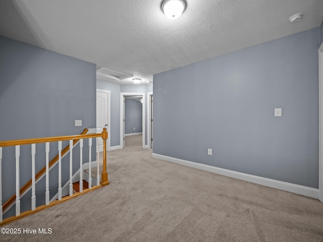 carpeted empty room featuring a textured ceiling