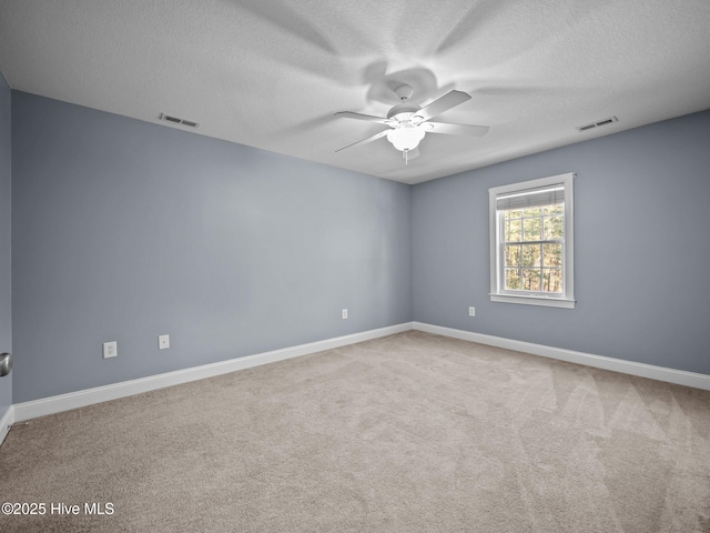 carpeted spare room featuring ceiling fan and a textured ceiling