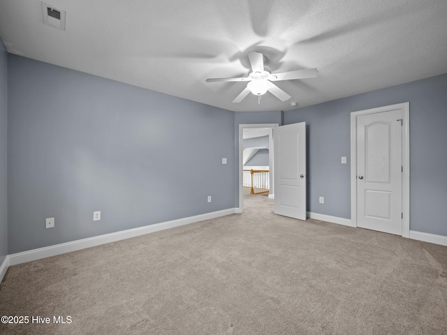 unfurnished bedroom featuring a textured ceiling, light colored carpet, and ceiling fan