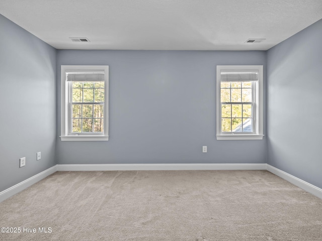 carpeted spare room featuring a textured ceiling