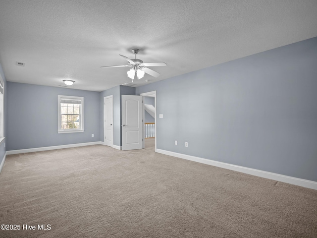 carpeted empty room featuring ceiling fan and a textured ceiling