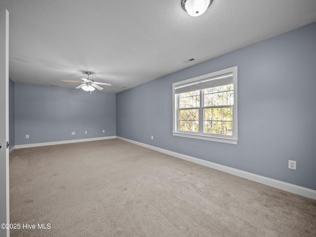 carpeted spare room featuring ceiling fan and a textured ceiling