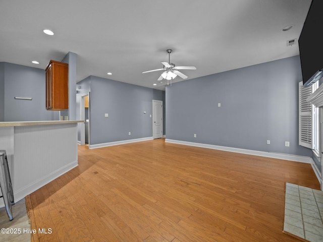 unfurnished living room featuring light hardwood / wood-style floors and ceiling fan