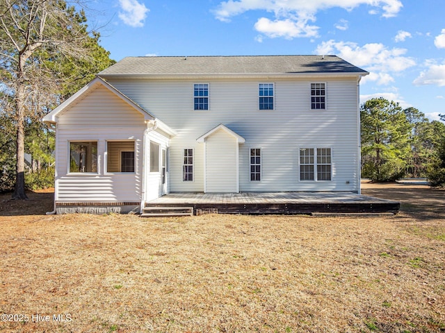 back of house with a deck and a lawn