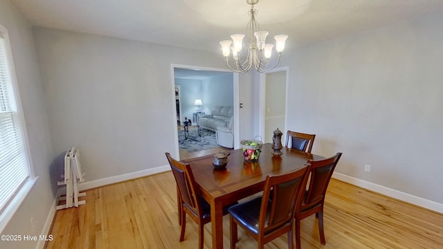 dining room featuring a notable chandelier and light wood-type flooring