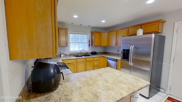 kitchen with appliances with stainless steel finishes, kitchen peninsula, and sink