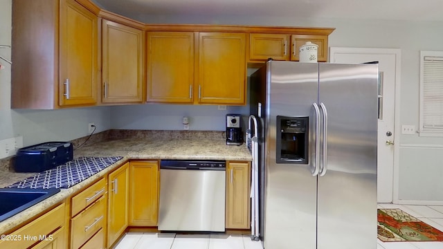 kitchen featuring stainless steel appliances and light tile patterned flooring