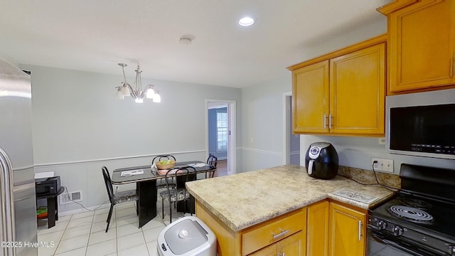 kitchen featuring appliances with stainless steel finishes, light tile patterned floors, and an inviting chandelier