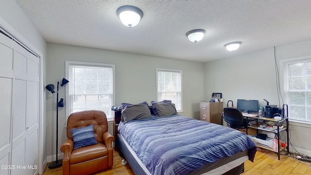 bedroom with hardwood / wood-style floors, a closet, and a textured ceiling