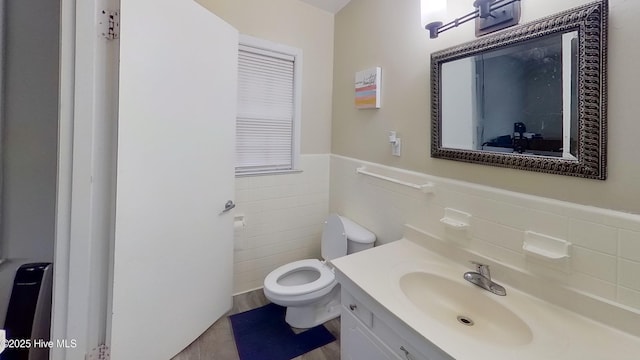 bathroom featuring vanity, tile walls, and toilet