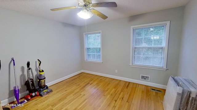 spare room with ceiling fan, radiator heating unit, and wood-type flooring