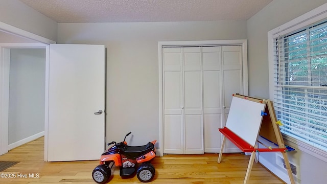 rec room with a textured ceiling and light wood-type flooring