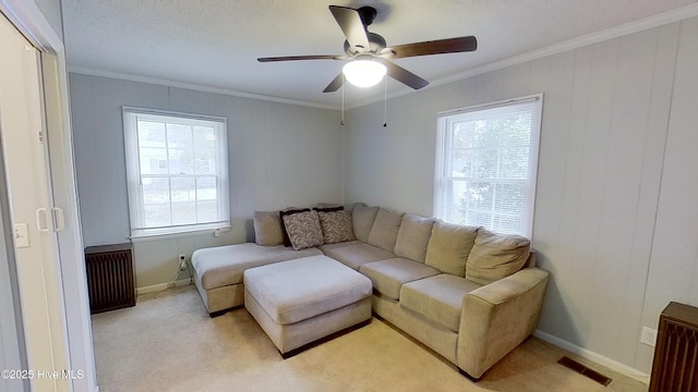 living room featuring ceiling fan, ornamental molding, radiator, and light carpet