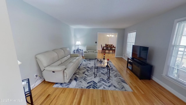 living room featuring an inviting chandelier and light hardwood / wood-style floors