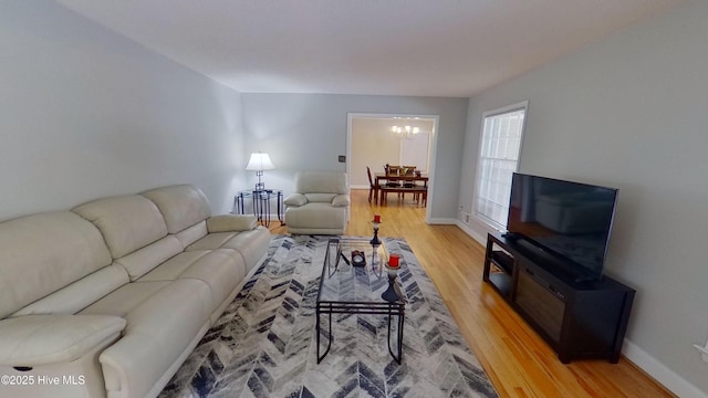 living room with wood-type flooring and a chandelier