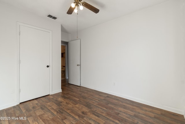 unfurnished bedroom featuring a ceiling fan, baseboards, dark wood-style floors, and visible vents