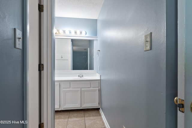 bathroom with baseboards, tile patterned flooring, and vanity