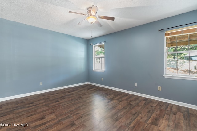unfurnished room featuring baseboards, ceiling fan, a textured ceiling, and dark wood-type flooring