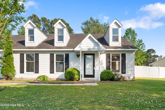 new england style home with fence and a front lawn