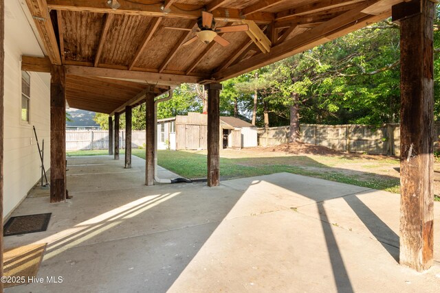 view of patio with an outbuilding, ceiling fan, and a fenced backyard