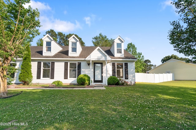 new england style home featuring fence and a front yard