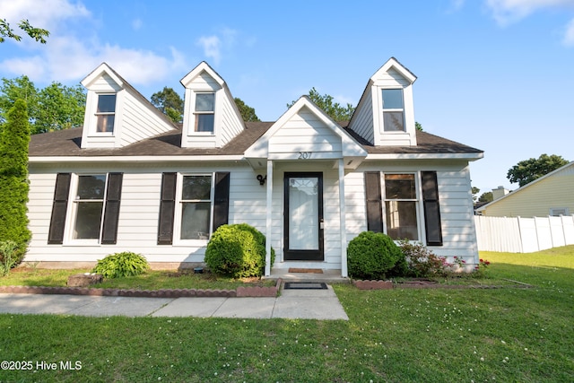 cape cod-style house with fence and a front yard