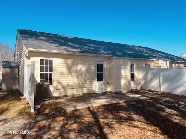 back of house featuring a patio, a shingled roof, cooling unit, and fence