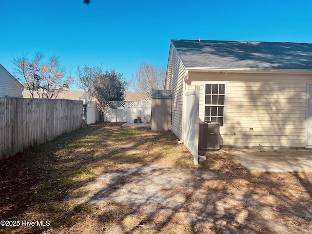 view of yard with a patio area, a fenced backyard, and central AC