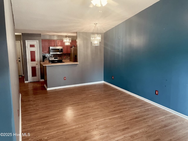 interior space with a chandelier, baseboards, and wood finished floors