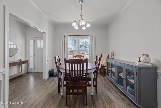 dining area with ornamental molding, a chandelier, and dark hardwood / wood-style flooring