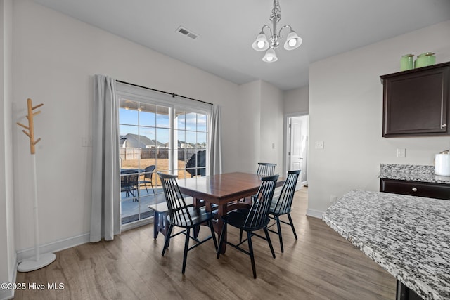 dining room with hardwood / wood-style floors and a notable chandelier