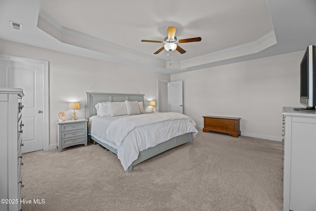 carpeted bedroom featuring ceiling fan, ornamental molding, and a tray ceiling