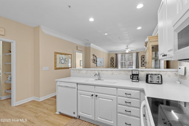 kitchen with crown molding, white appliances, sink, and white cabinets