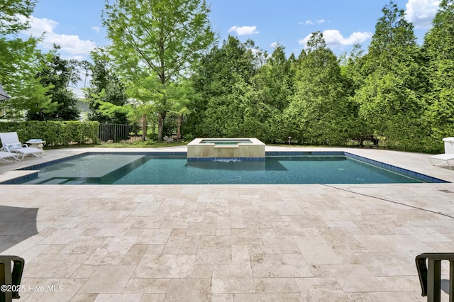 view of swimming pool with a patio, a pool with connected hot tub, and fence