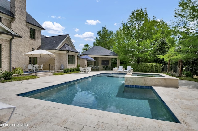 view of pool featuring outdoor dining area, a pool with connected hot tub, fence, and a patio area