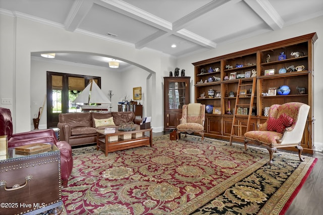 living area featuring wood finished floors, crown molding, beamed ceiling, arched walkways, and coffered ceiling