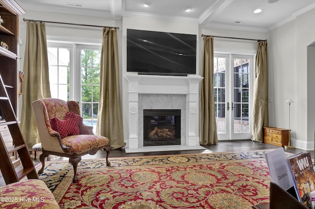 living area featuring a premium fireplace, plenty of natural light, wood finished floors, and ornamental molding
