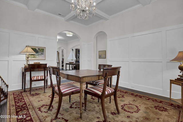 dining area featuring ornamental molding, visible vents, a decorative wall, arched walkways, and beam ceiling