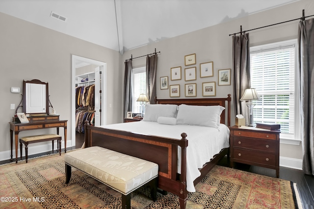 bedroom featuring lofted ceiling, a closet, baseboards, visible vents, and a spacious closet