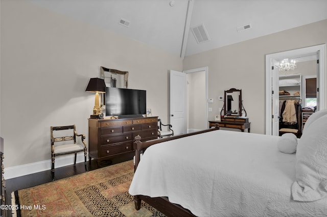 bedroom with baseboards, visible vents, and wood finished floors