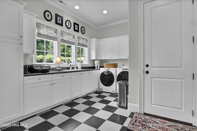 laundry room with a sink, cabinet space, dark floors, independent washer and dryer, and ornamental molding