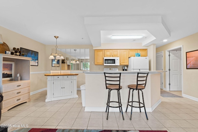 kitchen with white appliances, light tile patterned floors, light countertops, and a center island