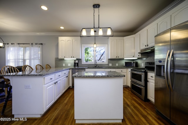 kitchen featuring pendant lighting, sink, appliances with stainless steel finishes, white cabinetry, and a kitchen island