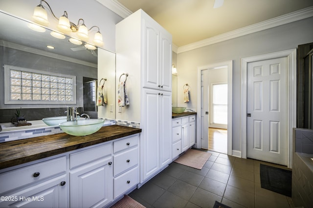 bathroom with tile patterned flooring, crown molding, vanity, and backsplash