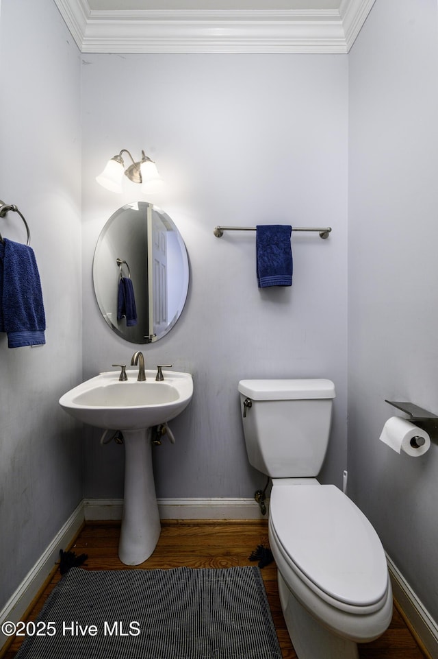 bathroom with hardwood / wood-style flooring, ornamental molding, and toilet