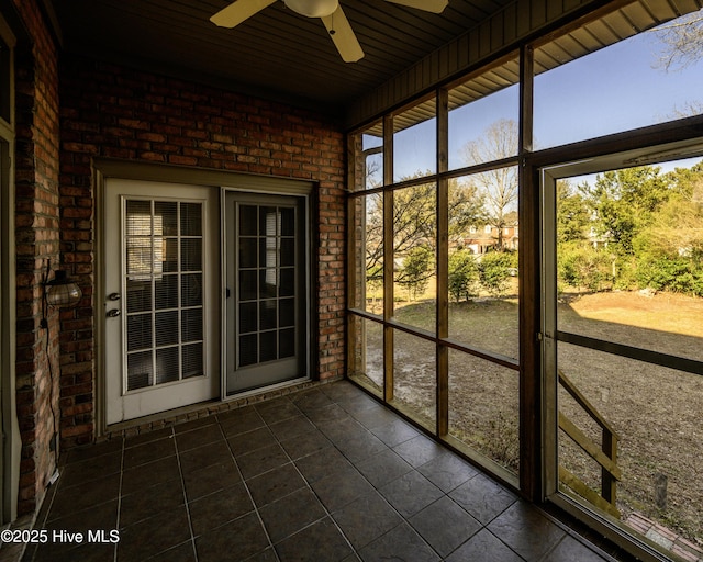 unfurnished sunroom featuring ceiling fan