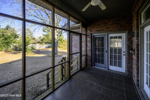 unfurnished sunroom with ceiling fan