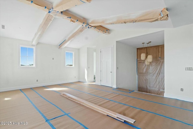 empty room with visible vents, baseboards, and vaulted ceiling with beams