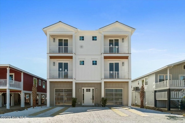 view of front of home featuring an attached garage and gravel driveway