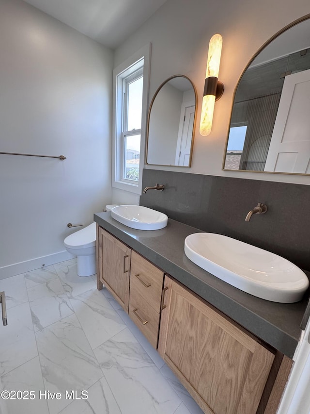 36 Fairmont St, Ocean Isle Beach, NC 28469 - full bathroom with marble look tiles, toilet, double vanity, and baseboards